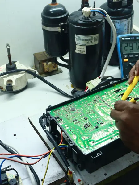 A technician testing a circuit board with meter probes
